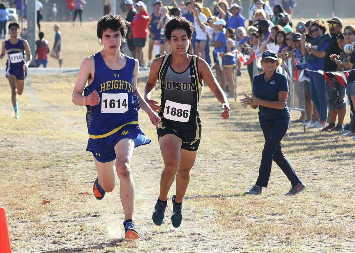 Alamo Heights Ian Donahue (1614) battles Edison’s Ricardo Gloria (1886) down to the finish as area high school teams compete in the District 27-5A Cross Country meet on Thursday, Oct. 13, 2022. Donahue finished in sixth and Gloria finished in seventh. Alamo Heights took the overall team win.