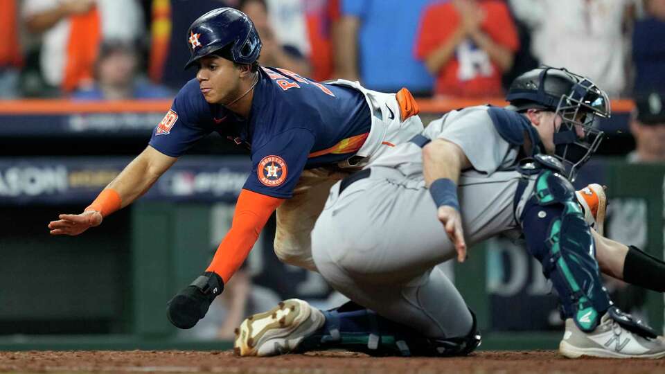 Houston Astros Jeremy Peña (3) beats the tag by Seattle Mariners catcher Cal Raleigh to score on Alex Bregman's RBI single in the ninth inning during Game 2 of the American League Division Series at Minute Maid Park on Thursday, Oct. 13, 2022, in Houston.