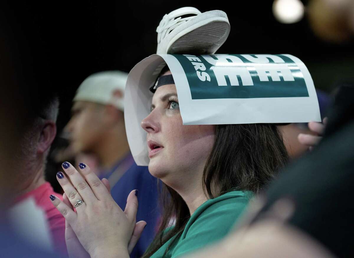 Seattle Mariners fans put shoes on top of their head to rally during top ninth inning of Game 2 of American League Division Series against the Houston Astros Thursday, Oct. 13, 2022, at Minute Maid Park in Houston.
