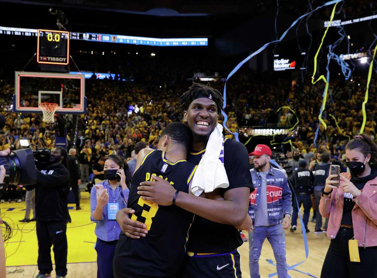 Jordan Poole (3) hugs Kevon Looney (5) after the Golden State Warriors defeated the Dallas Mavericks 120-110 in Game 5 of the Western Conference Finals to advance to the NBA Finals at Chase Center in San Francisco, Calif., on Thursday, May 26, 2022.