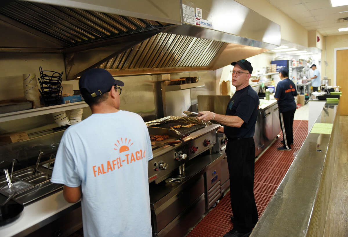 Owner Jonathan Langsam, center, in July 2022 in the kitchen of the new Falafel Taco in Greenwich, Conn.