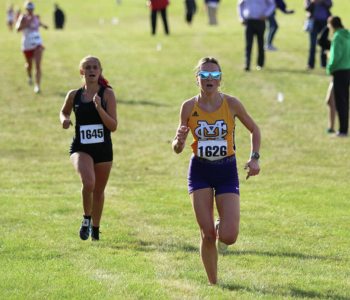 CM's Alyssa Mann (right) nears the finish line ahead of Highland's Maddie Dortch in the MVC Meet on Thursday at Principia College in Elsah. Both runners earned All-MVC honors with a top-15 finish.