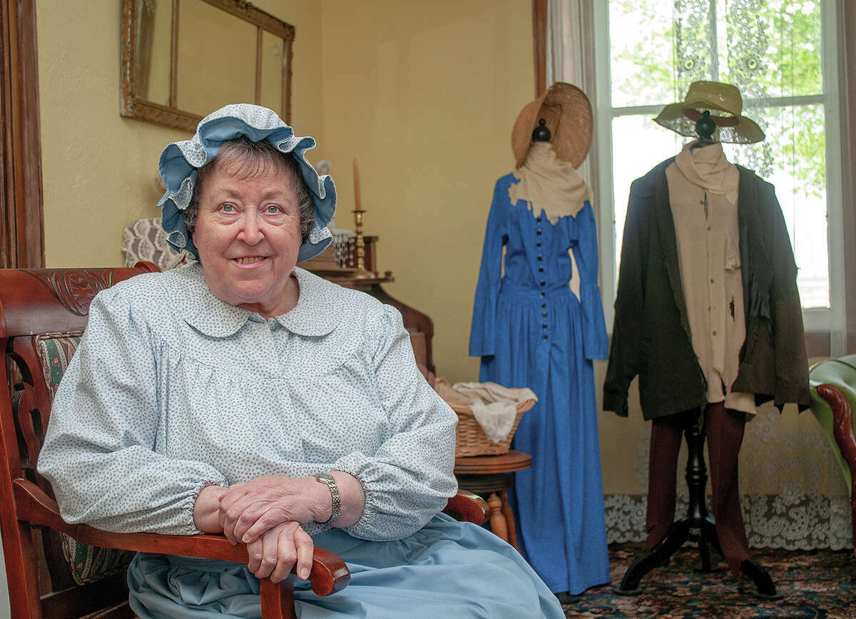 Volunteer Barbara Suelter wears clothing of the 1800s as she sits in a parlor at Woodlawn Farm.