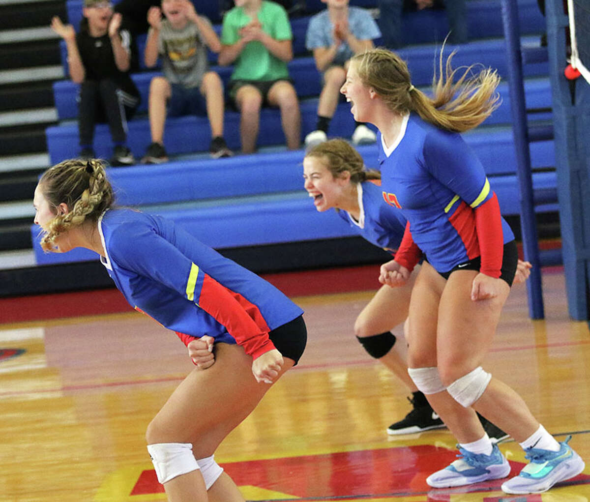 Roxana's Laynie Gehrs (back), Destiny Vuylsteke (right) and Peyton Petit celebrate a point during a Roxana Tourney match in August. On Thursday, the Shells and Oilers celebrated the raising of $12,000 for cancer research in their Digging for a Cure match in Wood River.