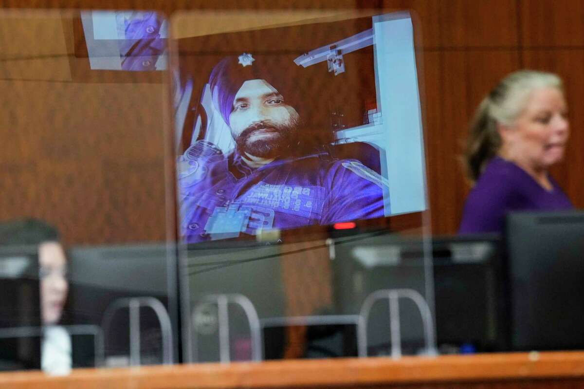 An image of slain Harris County Sheriff's Office Deputy Sandeep Dhaliwal is reflected on a plexiglass barrier in the courtroom during the capital murder trial against Robert Solis Friday, Oct. 14, 2022 in Houston. Solis, who accused of killing Dhaliwal, is representing himself in the case that carries the death penalty.