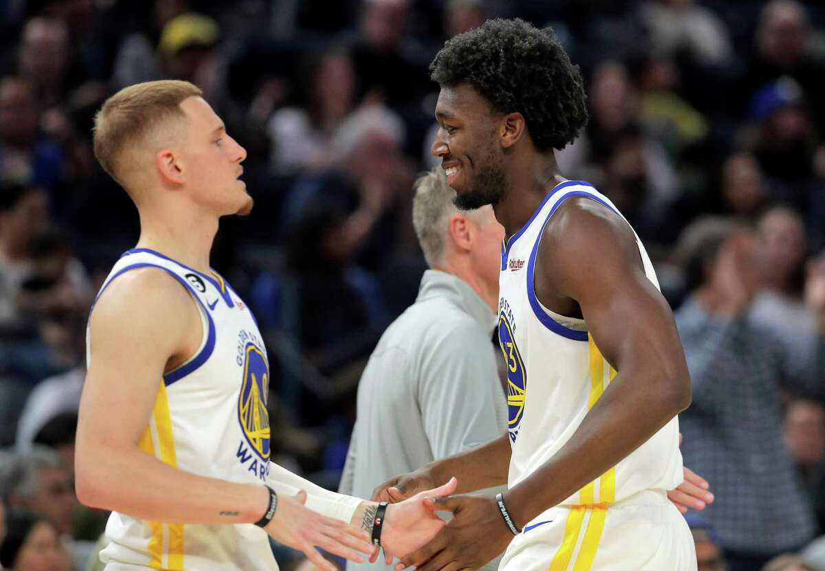 James Wiseman (33) high fives Donte DiVincenzo (0) after making a shot in the first half as the Golden State Warriors played the Los Angeles Lakers at Chase Center in San Francisco, Calif., on Sunday, October 09, 2022.