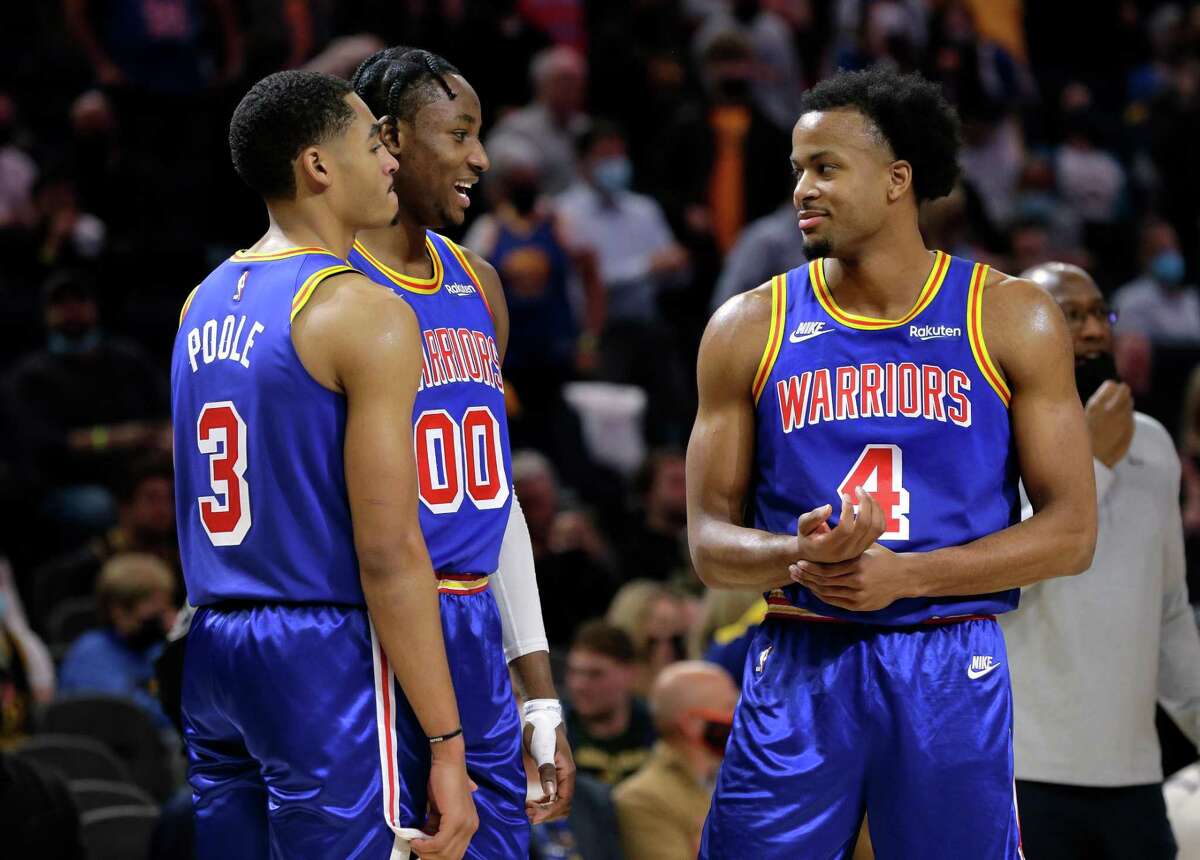Jordan Poole (3) with Jonathan Kuminga (00) and Moses Moody (4) during a timeout as the Golden State Warriors played the Detroit Pistons at Chase Center in San Francisco, Calif., on Tuesday, January 18, 2022.