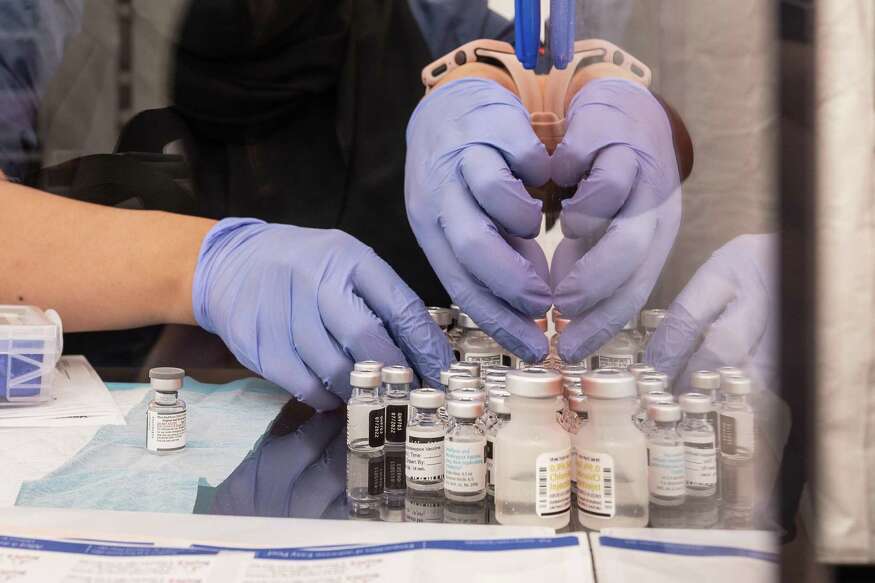 2022年9月23日，一名疫苗协调员在位于加利福尼亚州旧金山教会区的社区测试和疫苗接种诊所United in Health/Unidos en Salud补充新冠疫苗。