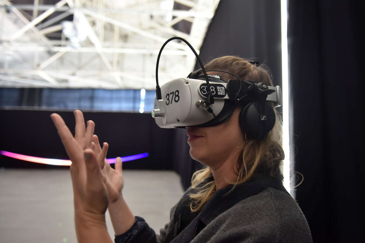 Jenna Starkey from San Francisco tries on the VR headset "the infinite," an immersive space experience currently housed in the Craneway Pavilion on Richmond's waterfront.