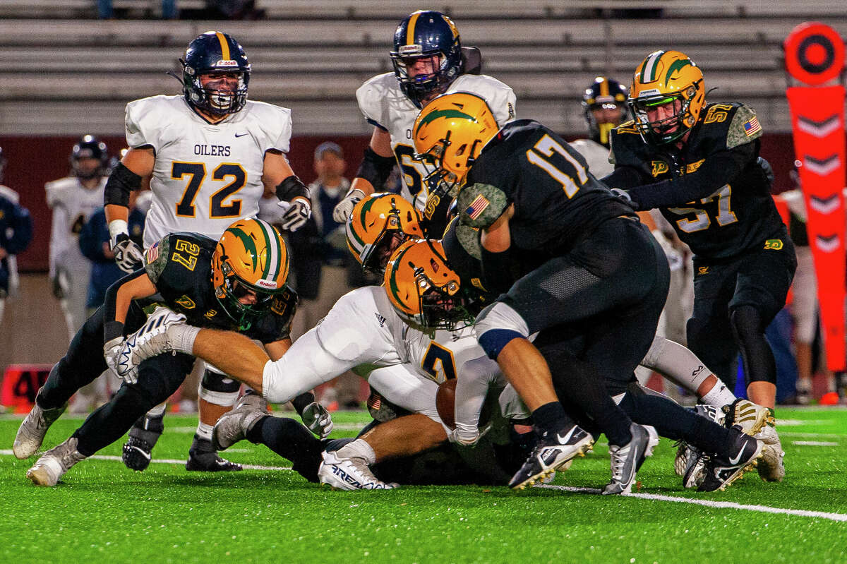 Dow and Mount Pleasant high school football players clash at a football game on Oct. 14, 2022 at Midland Community Stadium.
