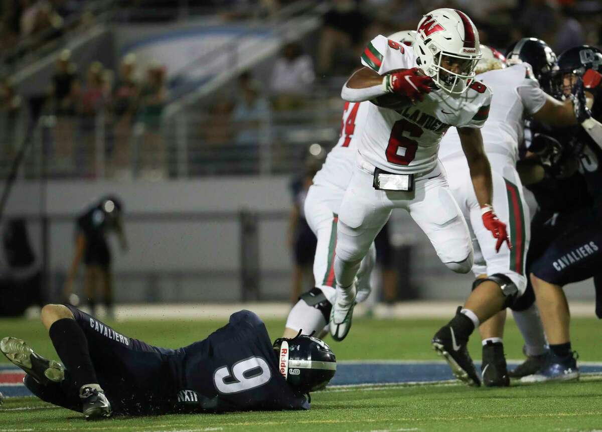 The Woodlands wide receiver Jason Williams (6) leaps past College Park linebacker Cole Walters (9) during the third quarter of a District 13-6A high school football game at Woodforest Bank Stadium, Friday, Oct. 14, 2022, in Shendoah.