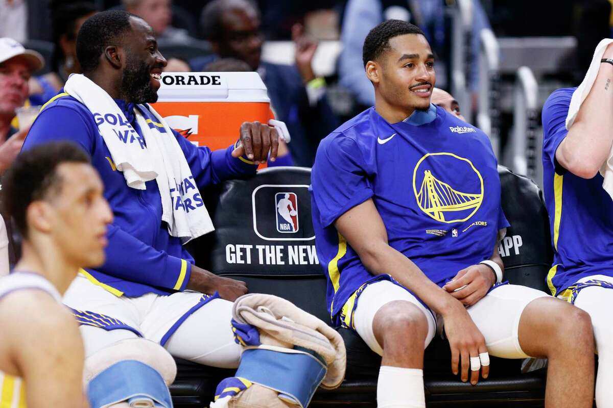 From left: Golden State Warriors forward Draymond Green (23) and Warriors guard Jordan Poole (3) on the bench in the first half of an NBA preseason game against the Denver Nuggets at Chase Center in San Francisco, Calif., Friday, Oct. 14, 2022.