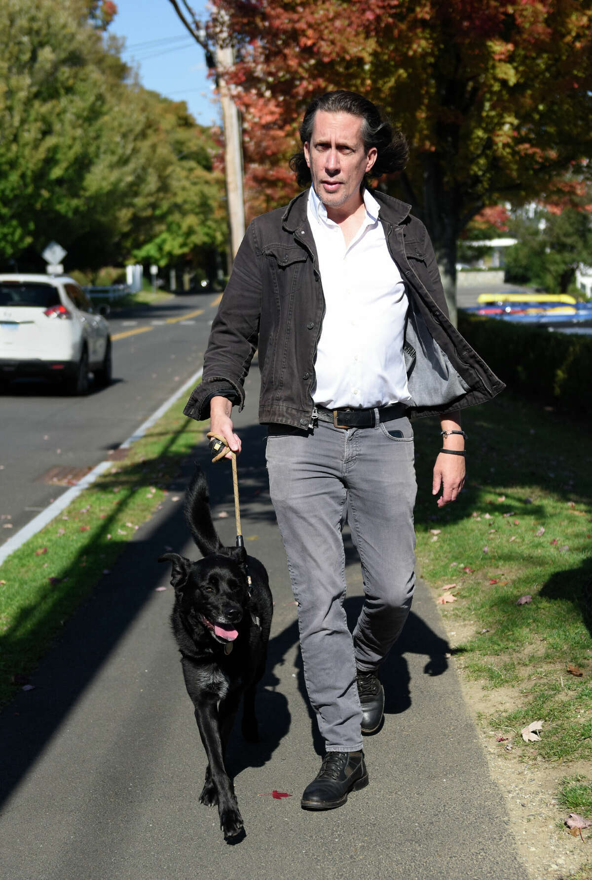 Photographer Jay Wilson walks his dog, Shadow, around his neighborhood in the Cos Cob section of Greenwich, Conn. Monday, Oct. 10, 2022. Wilson turned his nightly walks in his Greenwich neighborhood with his dog into a photographic exploration of "peace and safety" during COVID.Â His work is now on view at the Cos Cob Library through Oct. 31.