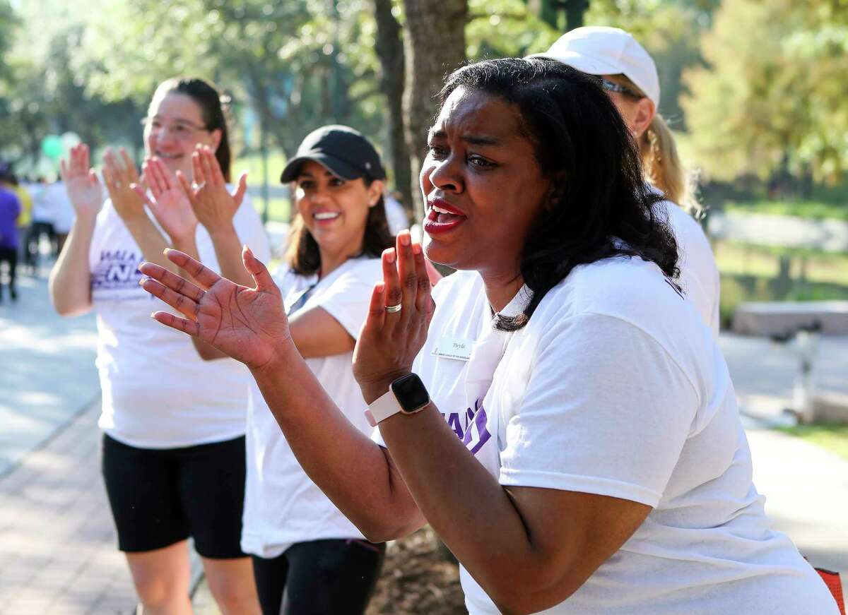 Volunteer Twyla Bozeman-Dean cheers on walkers during the North Harris County/Montgomery County Walk to End Alzheimers at Town Green Park, Saturday, Oct. 15, 2022, in The Woodands. More than 1,000 people participated in the annual walk, raising $200,000 for the Alzheimer's Association, which supports research and advocacy efforts.