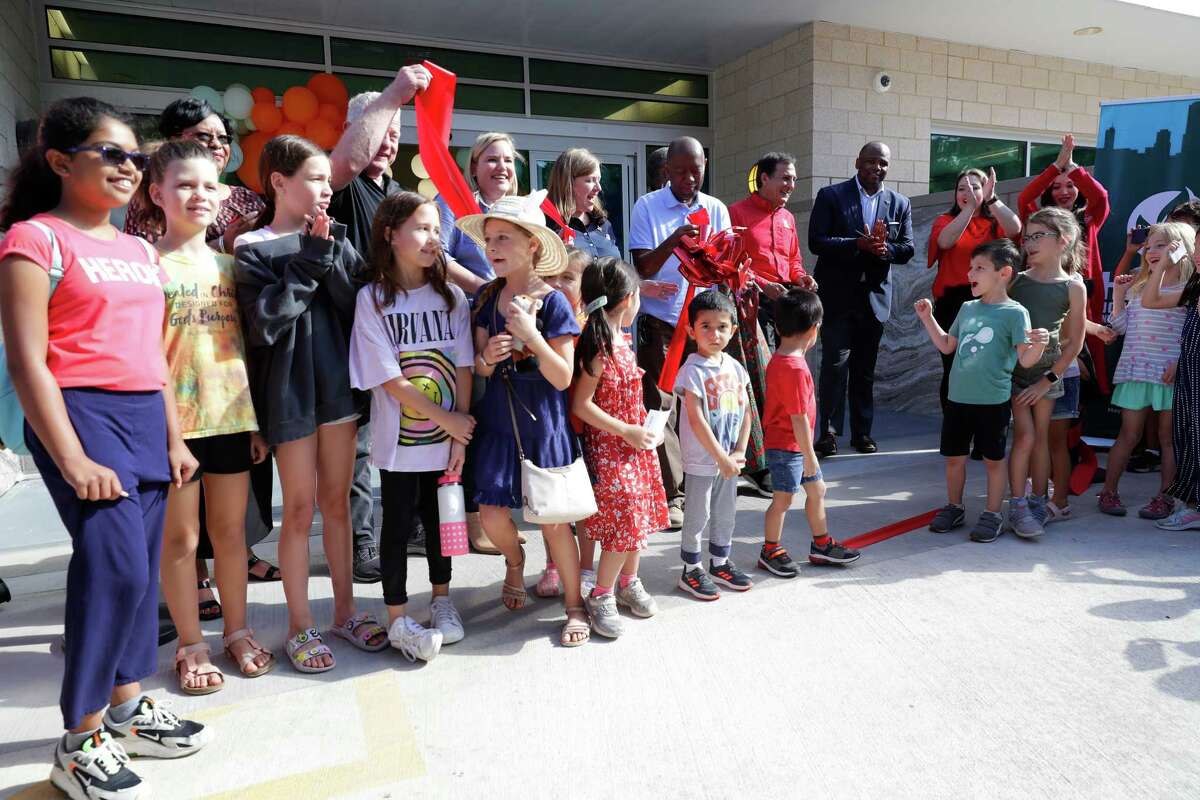 Kids join dignitaries for the ribbon-cutting during the reopening of the Belle Sherman Kendall Neighborhood Library and Community Center on Saturday. The library was damaged by Hurricane Harvey in 2017 and has undergone remodeling.