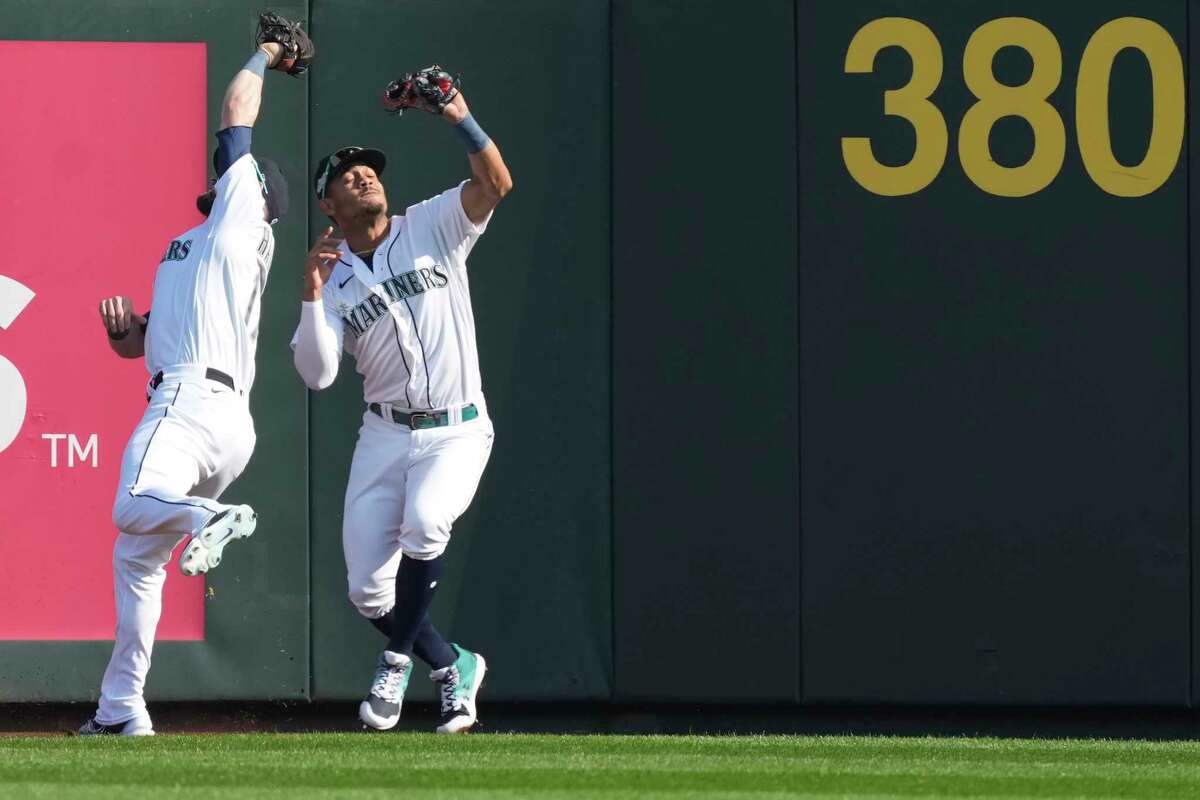 Seattle Mariners' Mitch Haniger (17) and Julio Rodriguez (44) nearly collide as Haniger makes the catch on a fly ball by Houston Astros' Jeremy Pena inning of Game 3 of the American League Division Series on Saturday, Oct. 15, 2022, in Seattle.