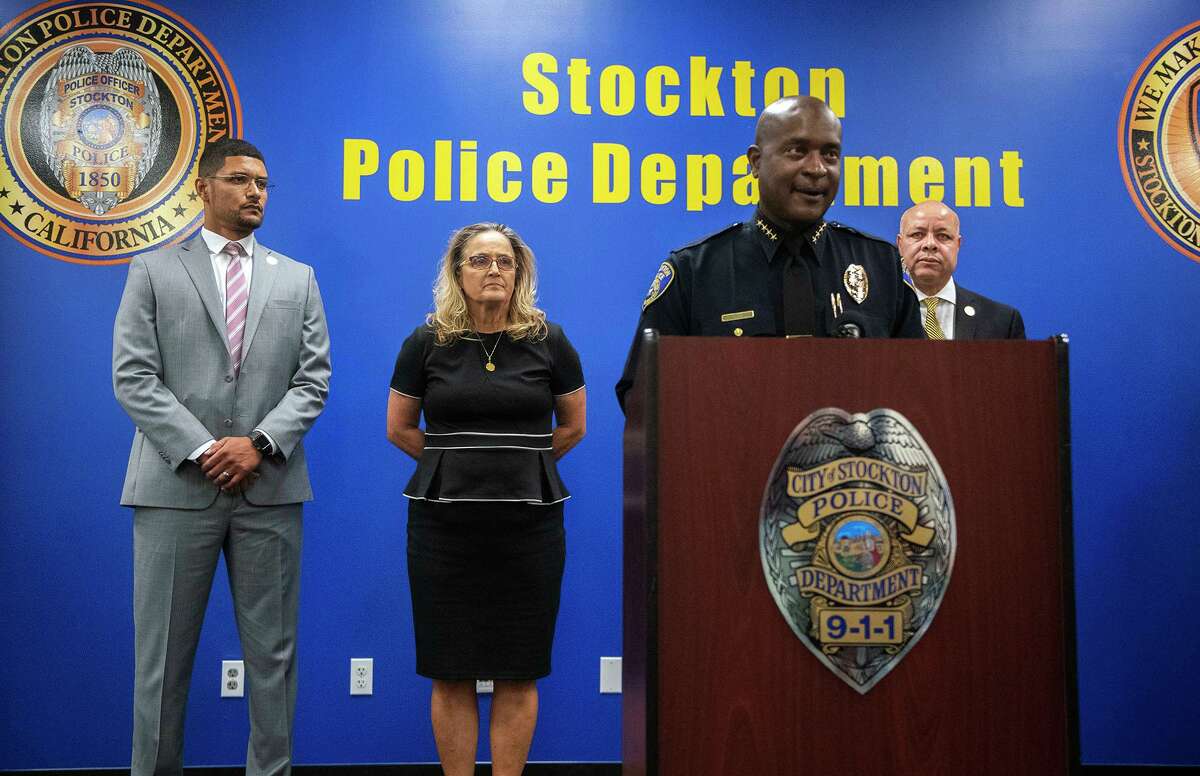 斯托克顿警察局长斯坦利·麦克法登星期六发表讲话，宣布逮捕了困扰该市的连环杀人案的一名嫌疑人。在他身后是斯托克顿市长凯文·林肯(左)、圣华金县地方检察官托里·韦伯·萨拉查和斯托克顿市经理哈里·布莱克。