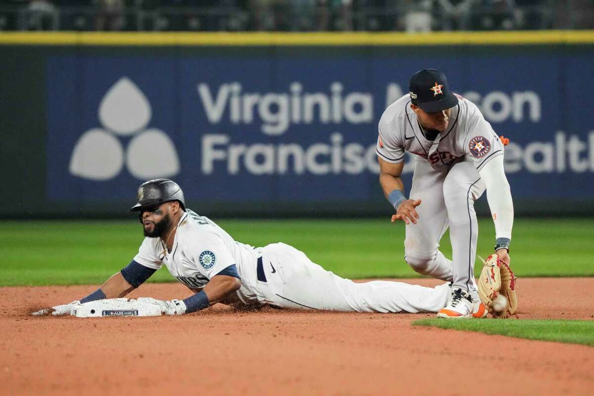Seattle Mariners designated hitter Carlos Santana (41) slides safety into second in front of Houston Astros shortstop Jeremy Peña on a play where the ball got away from catcher Christian Vasquez during the 17th inning of Game 3 of the American League Division Series on Saturday, Oct. 15, 2022, in Seattle.