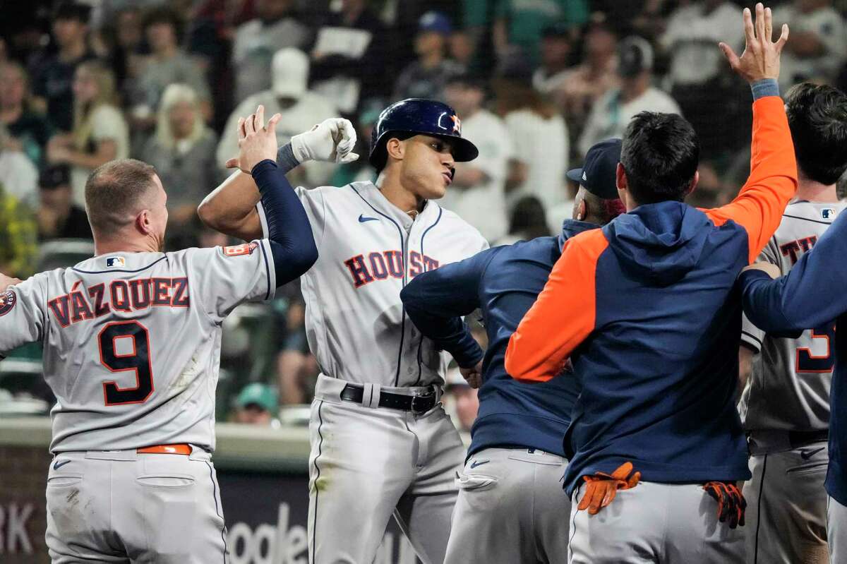 Shortstop Jeremy Peña, center, gets a hero's welcome after homering in the 18th inning for the only run in the Astros' Game 3 ALDS clincher over the Mariners.  