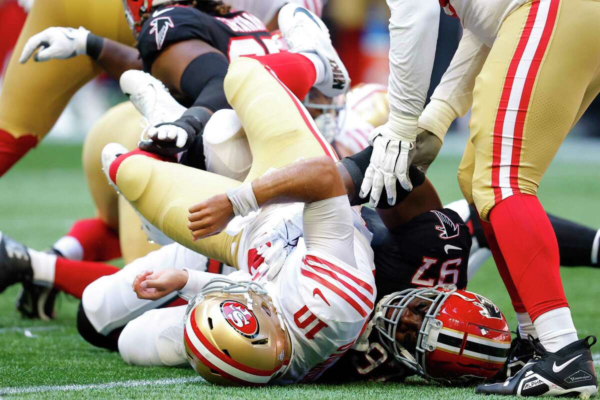 ATLANTA, GEORGIA - OCTOBER 16: Jimmy Garoppolo #10 of the San Francisco 49ers fumbles the ball while being hit by Grady Jarrett #97 of the Atlanta Falcons during the second quarter at Mercedes-Benz Stadium on October 16, 2022 in Atlanta, Georgia.