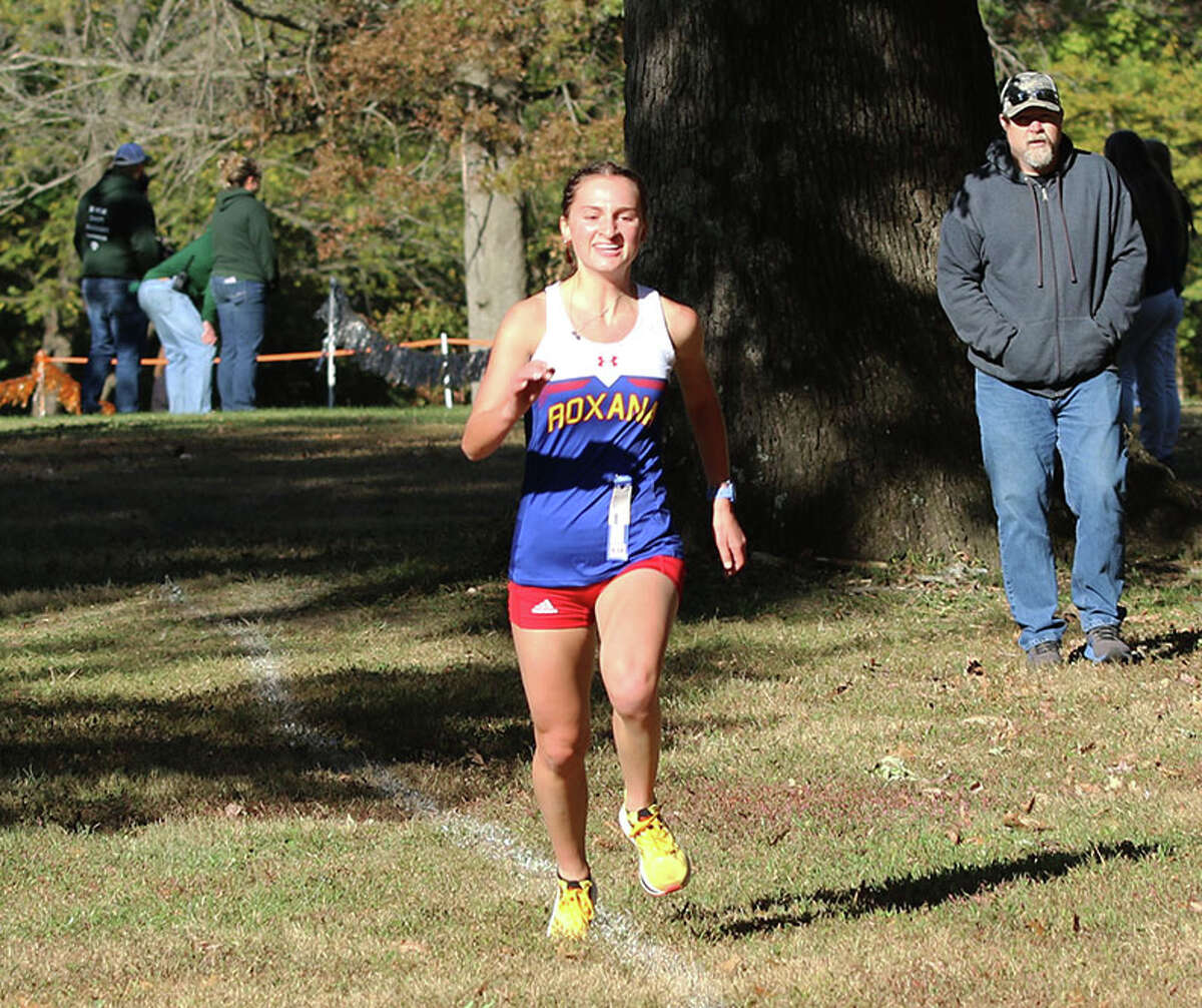 Roxana senior Gabrielle Woodruff enjoys ehe final meters of her run to a conference championship Saturday morning in the Cahokia Conference cross country meet at Bryan Memorial Park in Salem. Woodruff and the Shells won the Mississippi Division to deliver Roxana's first title in their new conference.