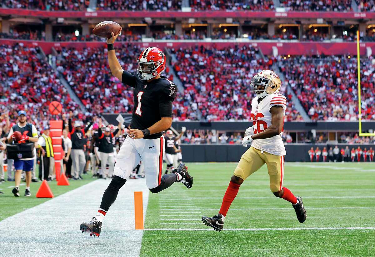 ATLANTA, GEORGIA - OCTOBER 16: Marcus Mariota #1 of the Atlanta Falcons runs past Samuel Womack III #26 of the San Francisco 49ers while scoring a touchdown during the second quarter at Mercedes-Benz Stadium on October 16, 2022 in Atlanta, Georgia. (Photo by Todd Kirkland/Getty Images)