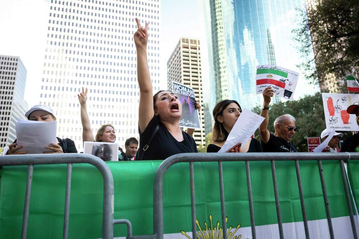 Sarir Mostafanejad and daughter Saba join hundreds of people as they demand for an end to the Islamic Republic’s rule in Iran at City Hall during a protest against and march in downtown Houston on Sunday, Oct. 16, 2022.