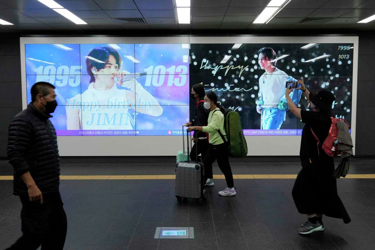 People pass by a screen installed to celebrate the birthday of Jimin, a member of South Korean K-pop band BTS, at a subway station in Seoul, South Korea, Thursday, Oct. 13, 2022.