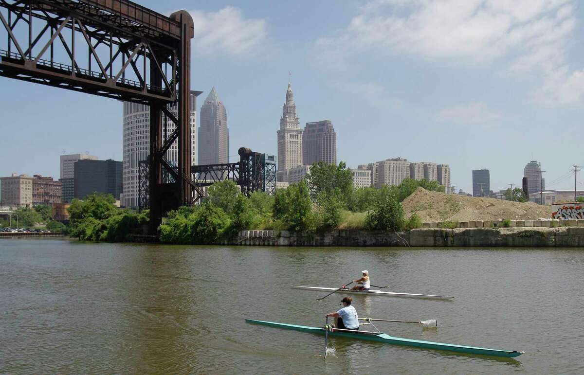 FILE – Two rowers paddle along the Cuyahoga River in Cleveland on July 12, 2011. Tuesday, Oct. 18, 2022, is the 50th anniversary of Congress passing the Clean Water Act to protect U.S. waterways from abuses like the oily industrial pollution that caused Ohio's Cuyahoga River to catch on fire in 1969.