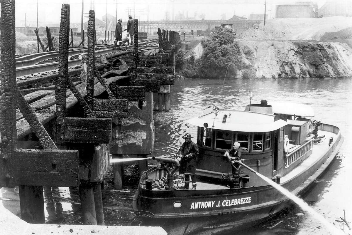 FILE - Cleveland firefighters aboard the Anthony J. Celebrezze fire boat extinguish hot spots on a railroad bridge torched by burning fluids and debris on the Cuyahoga River in 1969, in Cleveland. Fifty years ago, Congress passed the Clean Water Act to protect U.S. waterways from abuses like the oily industrial pollution that caused Ohio's Cuyahoga River to catch on fire in 1969. (Mitchell Zaremba/Cleveland.com via AP)