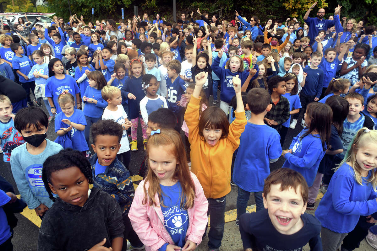 Students gather to watch a ribbon cutting ceremony in front of Booth Hill School, in Trumbull, Conn. Oct. 17, 2022. Booth Hill has been named a National Blue Ribbon School by the U.S. Department of Education.