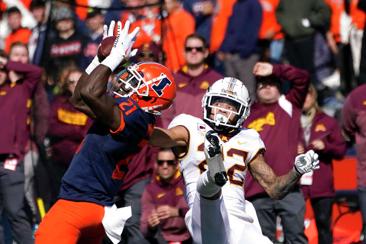 Illinois defensive back Jartavius Martin (21) intercepts a pass from Minnesota backup quarterback Athan Kaliakmanis intended for wide receiver Michael Brown-Stephens, right, during the second half of an NCAA college football game Saturday, Oct. 15, 2022, in Champaign, Ill. 