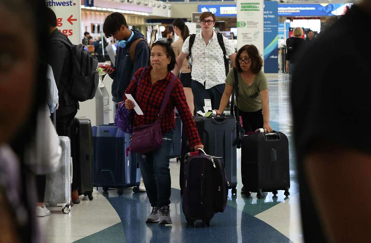 Travelers check in to their respective flights at the San Antonio International Airport on Wednesday, Oct. 12, 2022.