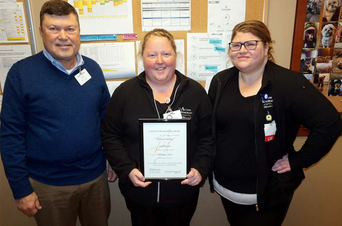 Brittani Melton, center, of the lab is Alton Memorial Hospital’s October Employee of the Month. She received the award Oct. 18 from AMH President Dave Braasch, left, and lab supervisor Melissa Crouch.