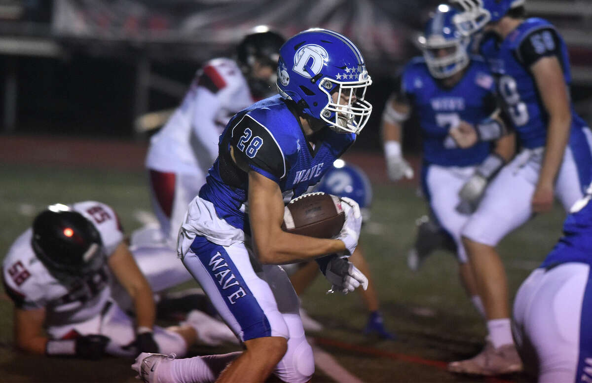 Darien's Trevor Herget (28) runs for some yards after a catch against Warde during a football game in Fairfield on Friday, Sept. 30, 2022.