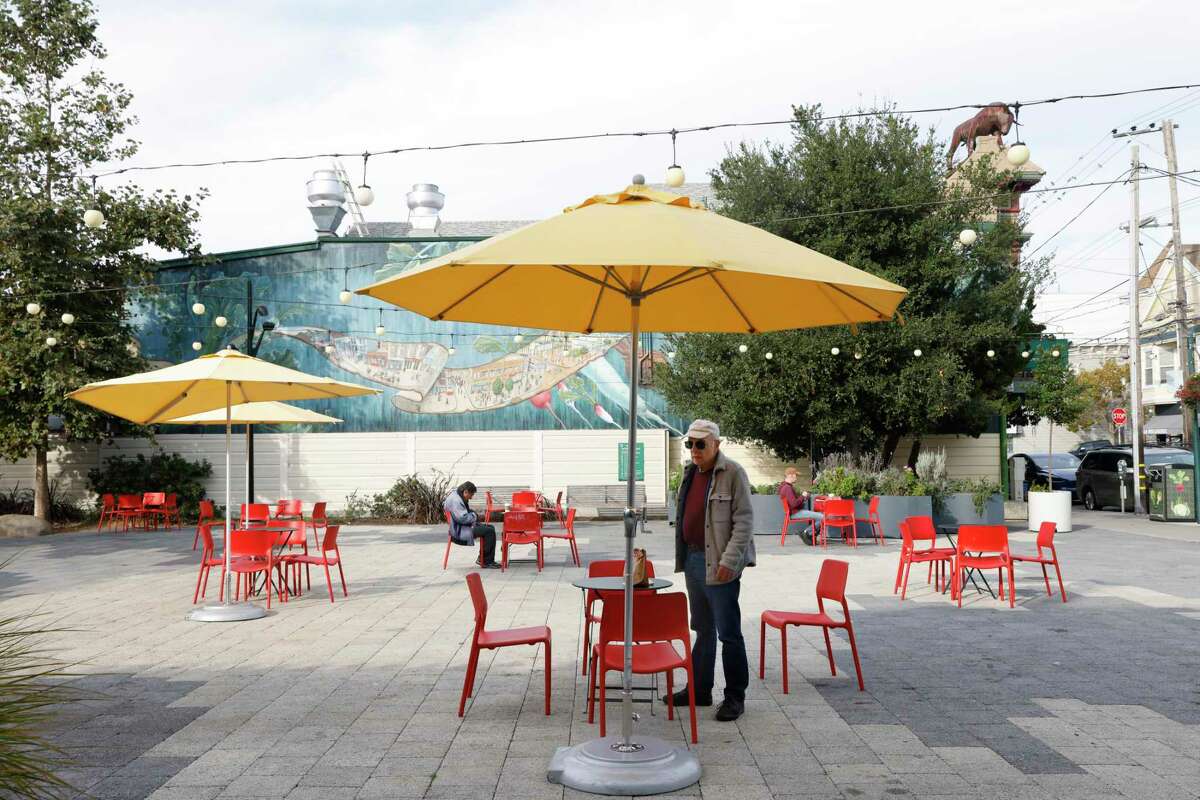 José Segue (center), San Francisco resident, occupies a table for himself and a friend at Noe Valley Town Square on Tuesday, October 18, 2022 in San Francisco, Calif. Noe Valley Town Square will be the site of the construction of a toilet stall that will cost $1.7 million and take more than two years to build.