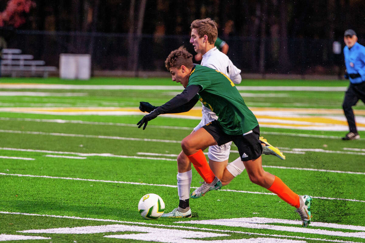 Dow High school soccer player Nico Scorsone fights for a soccer ball at a district semifinal game on Oct. 18, 2022 at Dow High School.