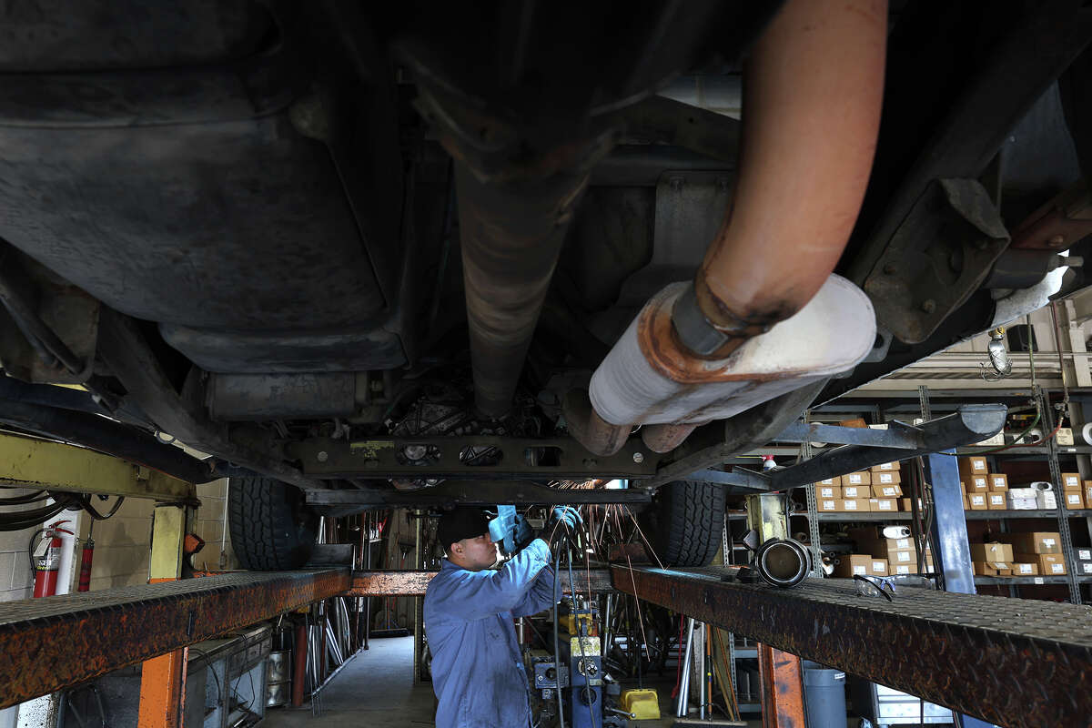 Luis Benitez welds a new catalytic converter onto a Chevrolet Silverado at Johnny Franklin's Muffler on July 11, 2022, in San Rafael, Calif.