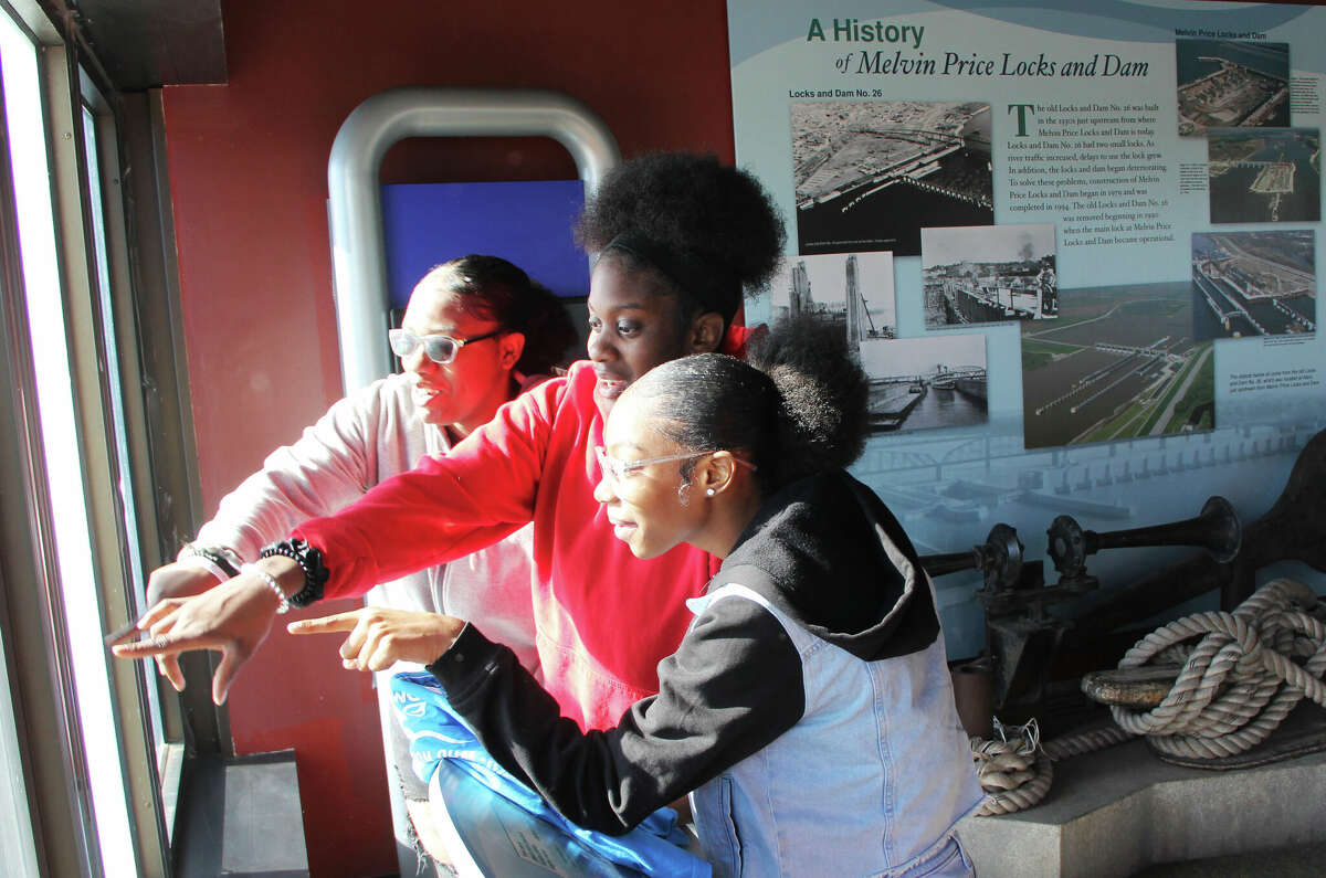 Alton High School students Jariah Webber, right, Keviona Usher and La'Jadia Smith look out of the observation room over the main lock at Lock and Dam 26 Wednesday during “Who Works the Rivers,” at the National Great Rivers Museum in Alton Wednesday. The program brings in representatives of government and industry that provide jobs and services related to the river.