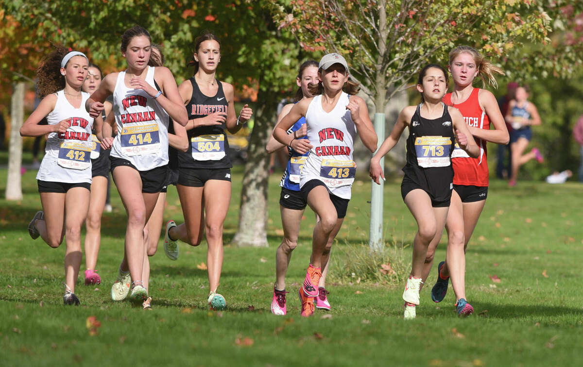 Trumbull's Kathryn Marchand (713), Greenwich's Esme Daplyn (far right), New Canaan's Radea Raleva (413), Eliana Savelli (414) and Charlotte Moor (412), and Ridgefield's Georgia Keller (504) race down a hill during the FCIAC girls cross country championship in New Canaan's Waveny Park on Wednesday, Oct. 19, 2022.