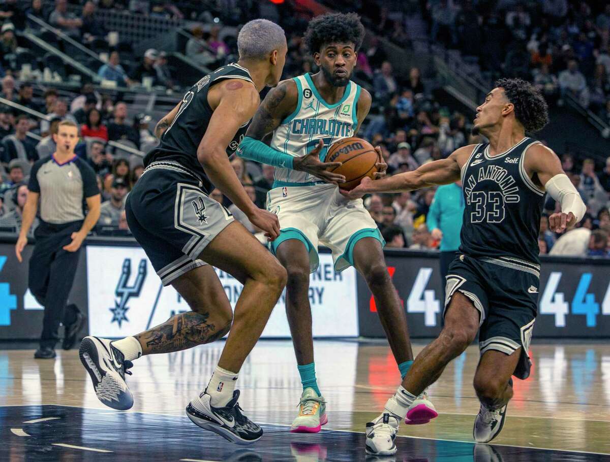 San Antonio Spurs guard Tre Jones gets his hand on the ball Wednesday night, Oct. 19, 2022, in the AT&T Center while defending against Charlotte Hornets forward Jalen McDaniels during the second half of their regular season opening night matchup.
