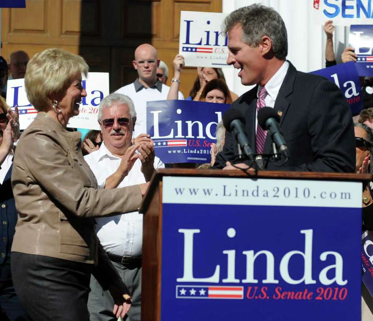 Linda McMahon, left, and Massachusetts senator Scott Brown, right, shake hands after Brown introduced McMahon during a rally in Milford on Saturday, October 9, 2010.