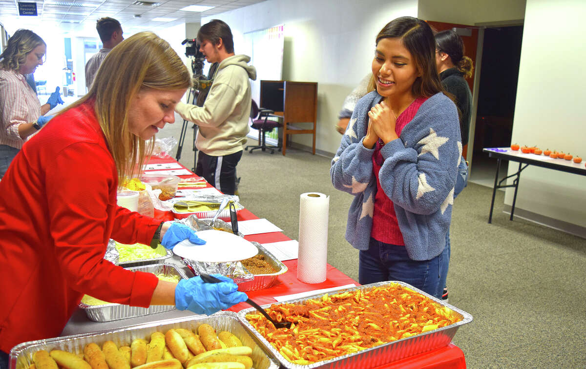 Lincoln Land Community College-Jacksonville Director Keri Mason helps serve food to Karen Esparza and other students during the college's Multicultural Fest.
