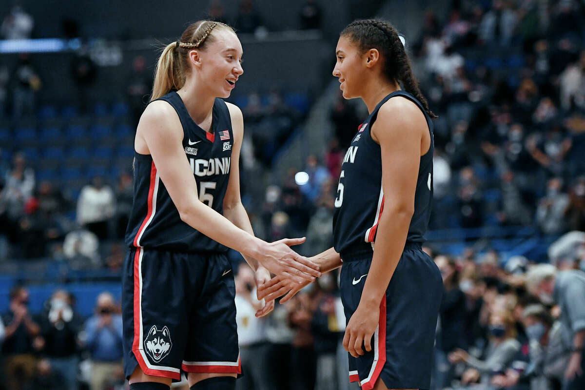 Connecticut's Paige Bookers (left) shakes hands with teammate Azi Fudd at the end of the NCAA college basketball game against Arkansas on Sunday, November 14, 2021 in Hartford, Connecticut.  (AP Photo/Jessica Hill)