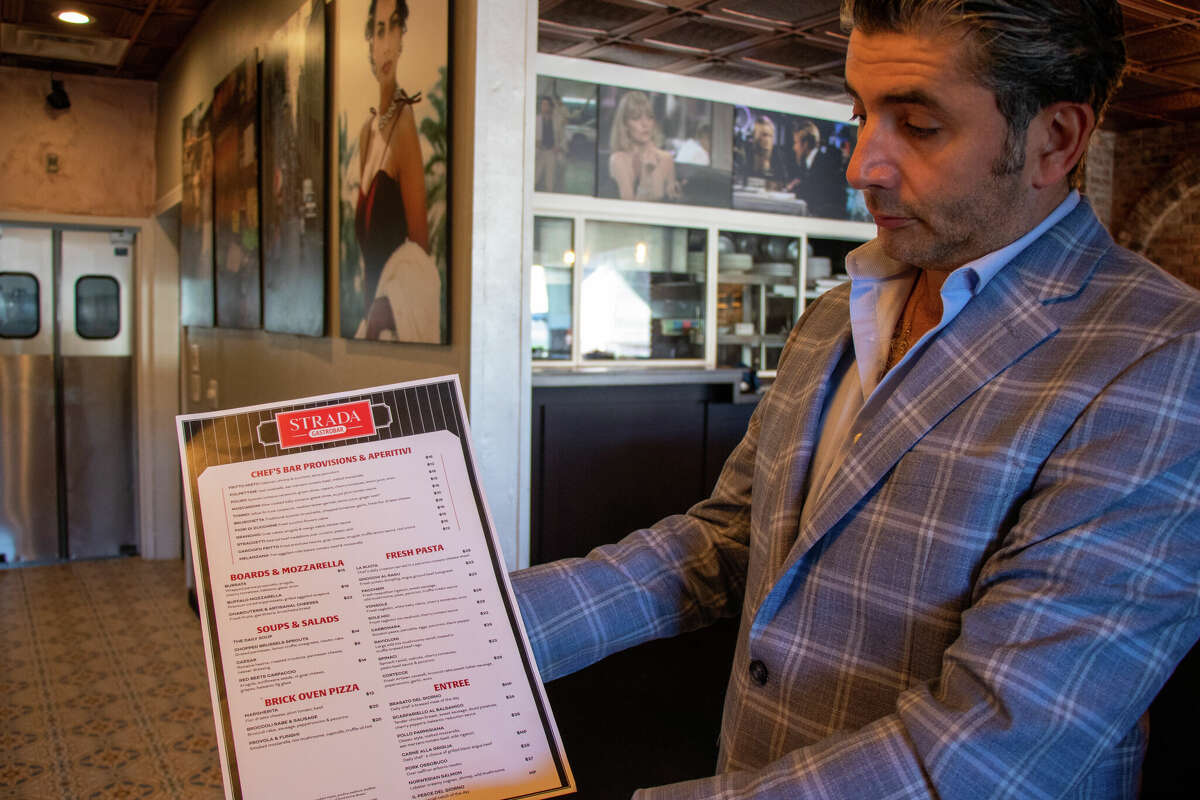 Giuseppe Cinque holds the menu for Strada Gastrobar in Milford on Oct. 20, 2022. Cinque brings more than 30 years of experience in the restaurant business.
