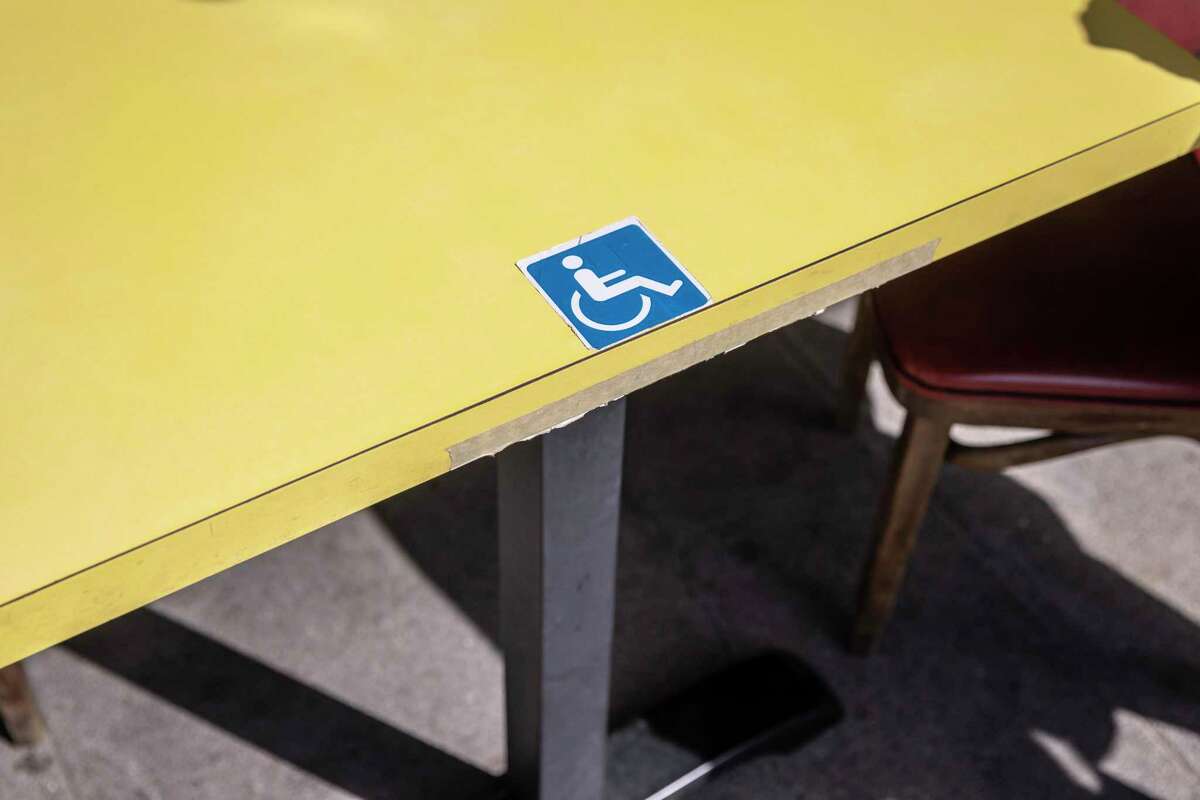An access symbol is seen on an Americans with Disabilities Act-compliant table outside Hon's Wun-Tun House in the Chinatown neighborhood of San Francisco.