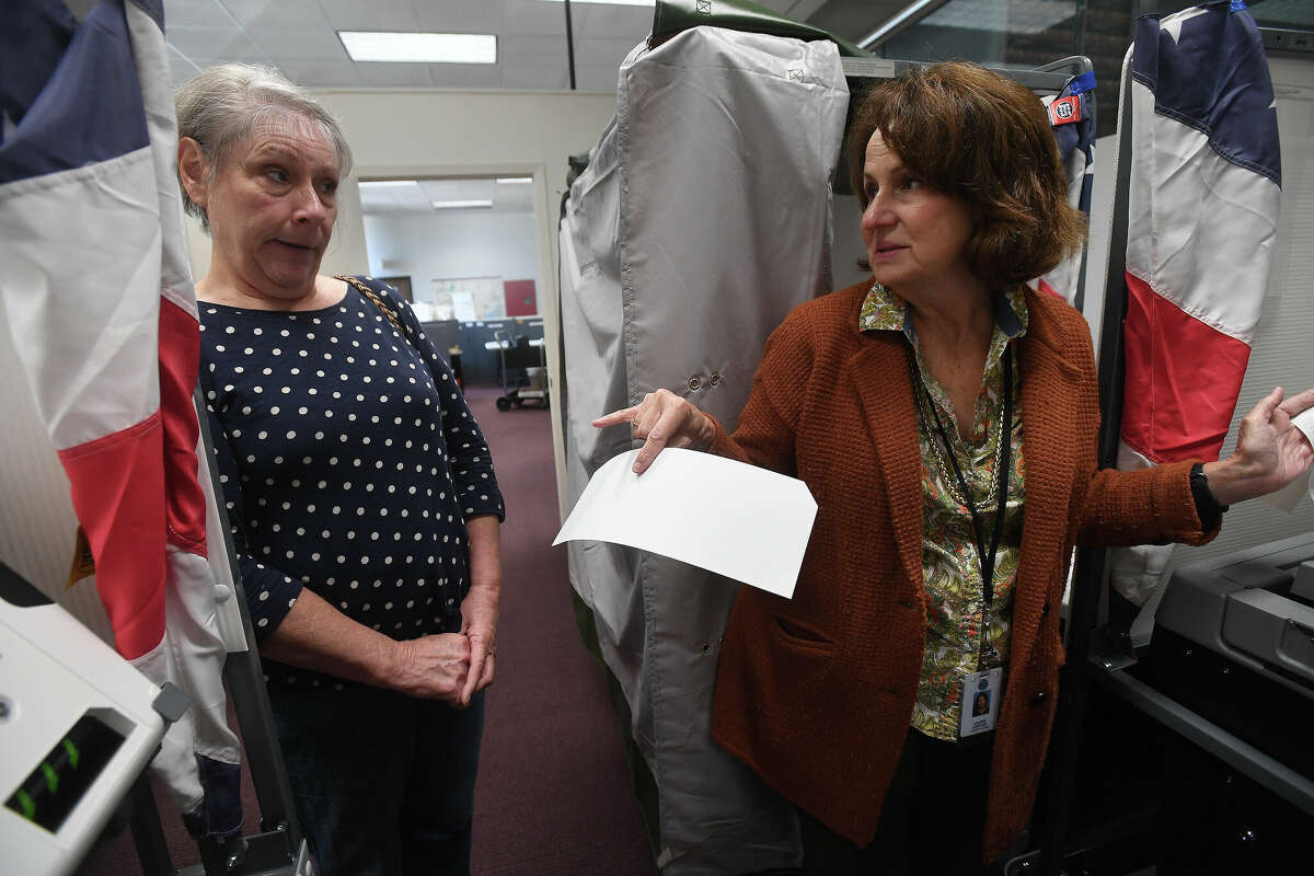 Jefferson County Clerk Laurie Leister talks with polling judge Linda Sherman, who stopped to try out one of the demo ESS voting machines, which remained in the office for poll workers to continue training on the new systems before early voting starts Monday. Photo made Thursday, October 20, 2022 Kim Brent/Beaumont Enterprise