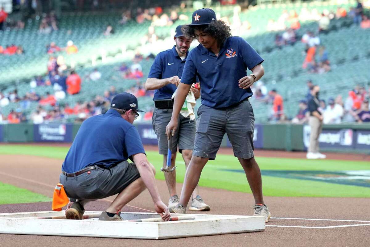 Houston Astros grounds crew workers prepare the field before Game 2 of the American League Championship Series at Minute Maid Park on Thursday, Oct. 20, 2022, in Houston.