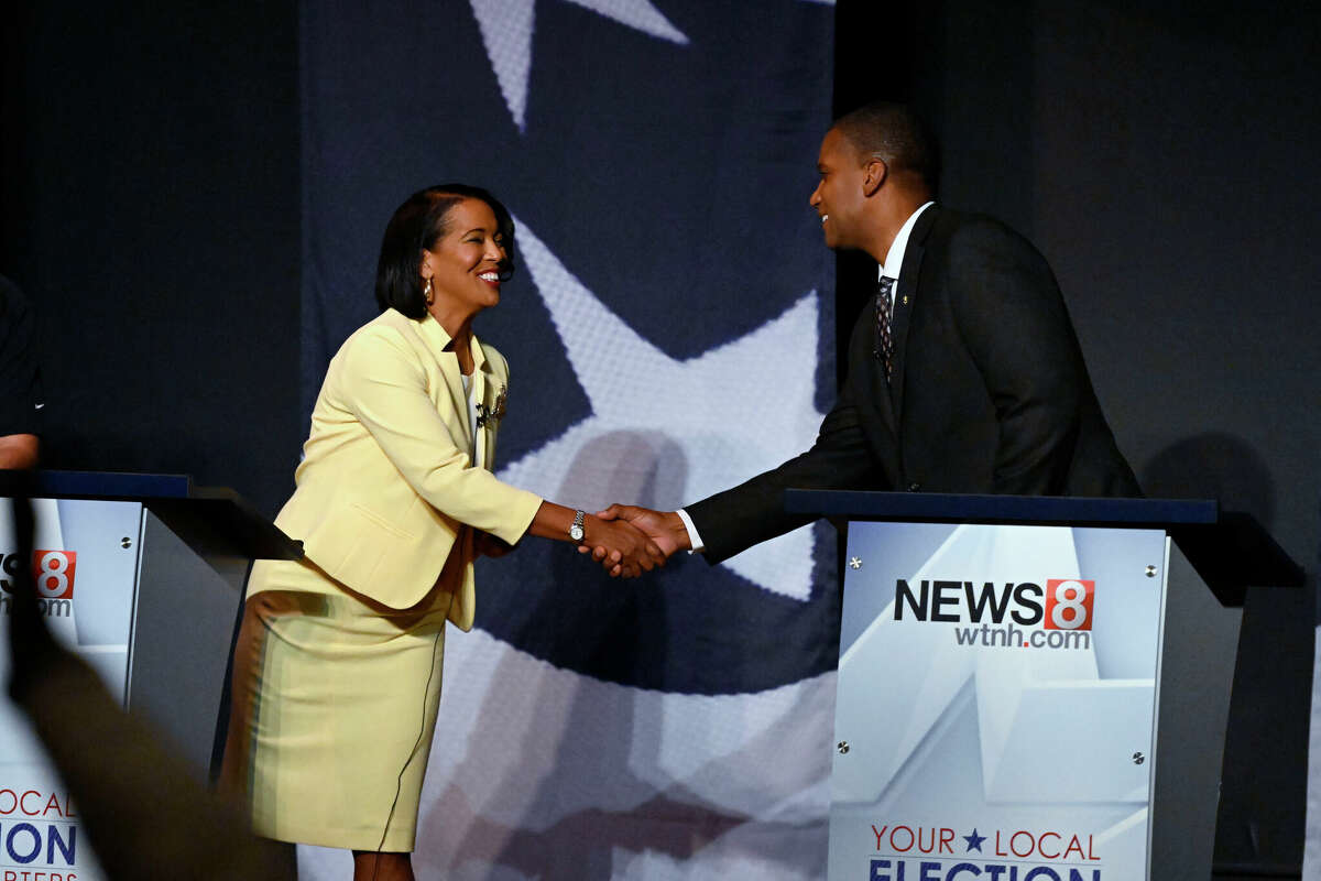 U.S. Rep. Jahana Hayes, D-Conn., left, shakes hands with Republican House candidate George Logan before a debate, Tuesday, Oct. 18, 2022, in Waterbury, Conn.