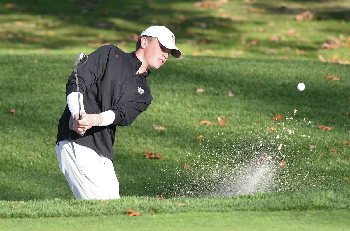 New Canaan's Cullen McCarthy hits out of the sand on the 16th hole at Rolling Hills CC during the FCIAC boys golf championship on Thursday, Oct. 20, 2022.